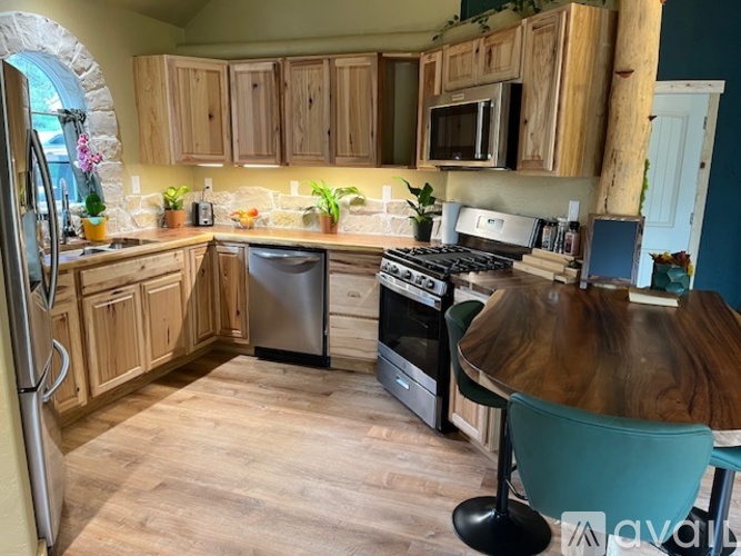 A kitchen with wooden cabinets and a stone archway.