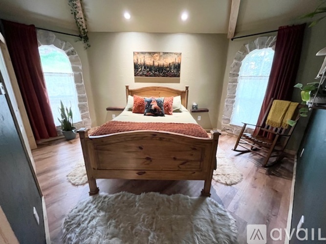 A bedroom with a large bed and a painting on the wall.