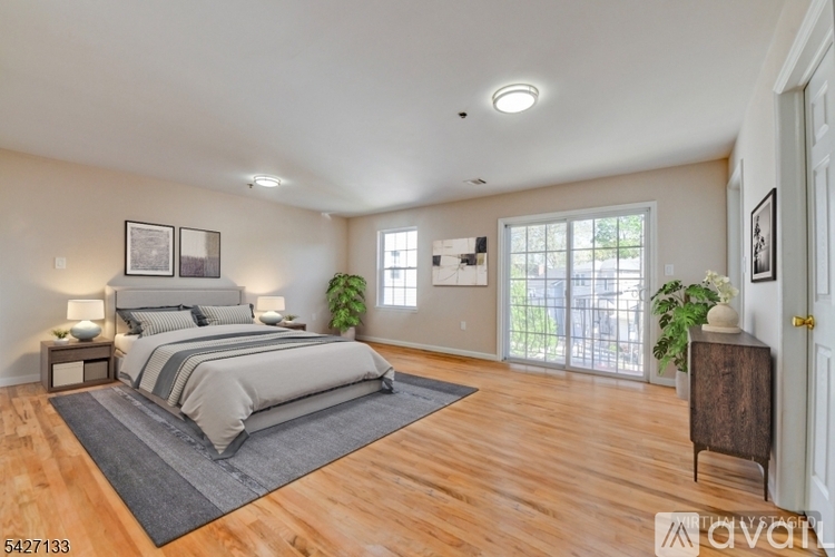 A bedroom with a large bed and a sliding glass door.