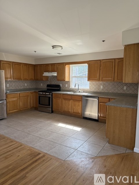 A kitchen with wooden cabinets and a tiled floor.