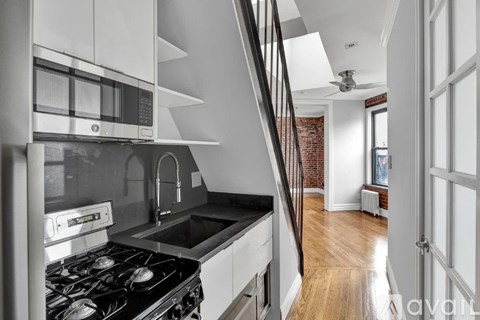 A modern kitchen with a stove top oven and a microwave above the stove.