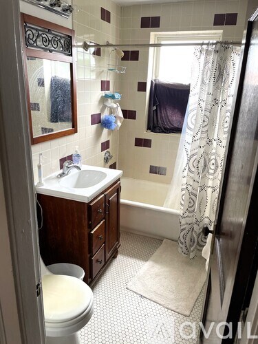 A bathroom with a toilet, sink, and shower.