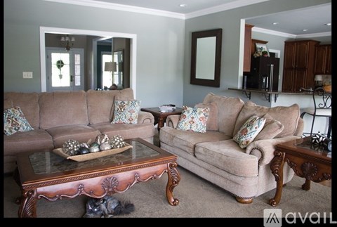 A living room with a brown couch and a coffee table.