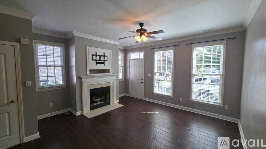 A living room with a fireplace and a ceiling fan.