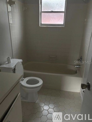 A bathroom with a toilet, sink, and tub.