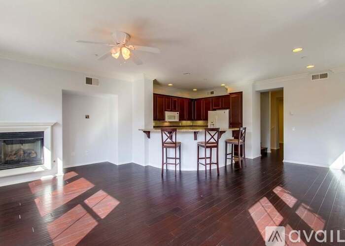 A living room with a fireplace and a dining area with a table and chairs.