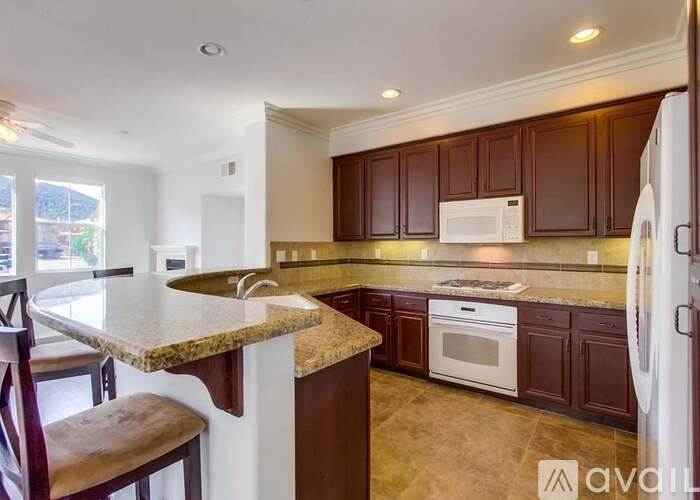 A kitchen with brown cabinets and a granite countertop.