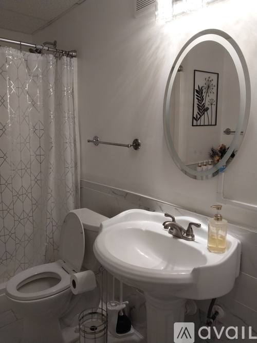 A bathroom with a toilet, sink, and mirror.