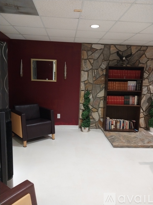 A room with a chair, a television, and a bookshelf.