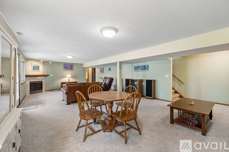 A living room with a fireplace and a dining table with chairs.