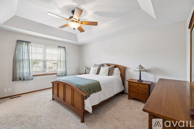A bedroom with a bed, nightstand, and window.