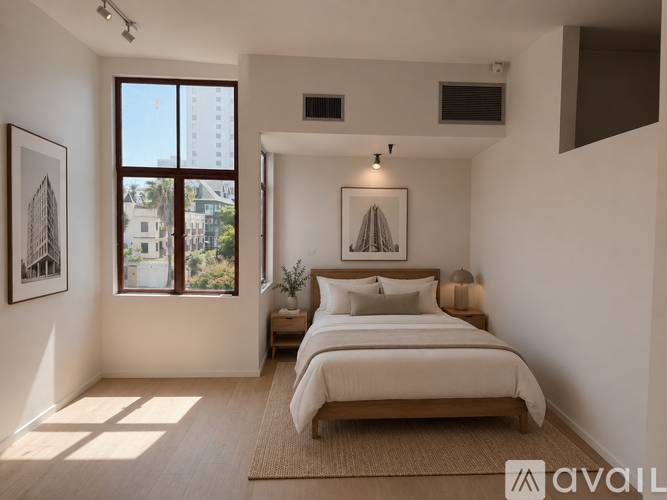 A bedroom with a large bed and a window overlooking a cityscape.
