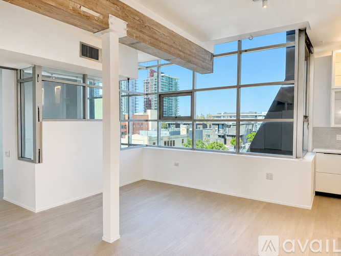 A spacious room with a large window overlooking the city.