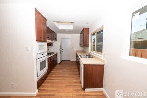 A kitchen with wooden floors and white appliances.