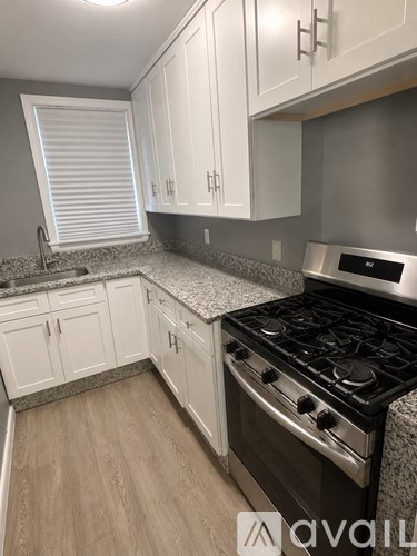 A kitchen with white cabinets and a black stove top oven.