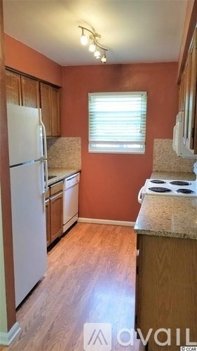 A kitchen with a white refrigerator and wooden cabinets.