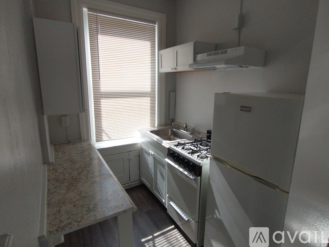 A kitchen with a stove top oven and a refrigerator.