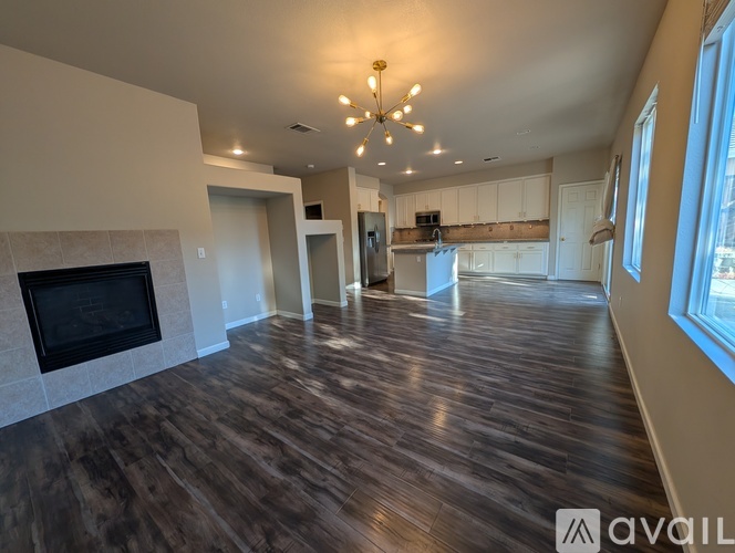 A spacious living room with wood flooring and a fireplace.