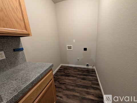 A kitchen area with wooden cabinets and a granite countertop.