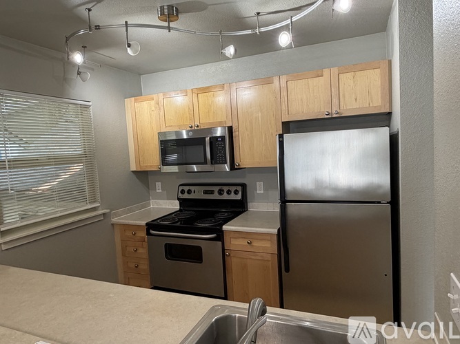 A kitchen with wooden cabinets and stainless steel appliances.