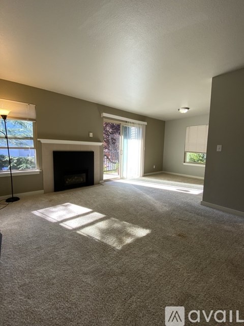 A living room with a fireplace and a carpet.