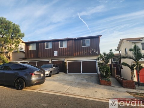 A modern house with a brown exterior and a car parked in front.