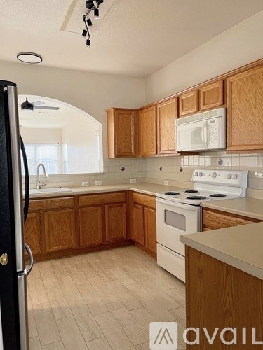 A kitchen with wooden cabinets and white appliances.