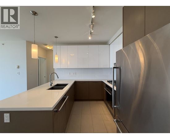 A modern kitchen with a stainless steel refrigerator and white countertops.