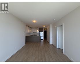 A spacious room with wooden floors and white walls.