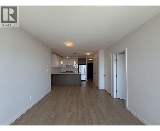 A spacious room with wooden floors and white walls.