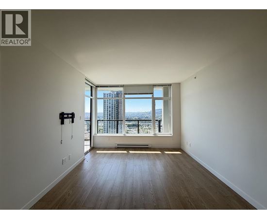 A room with a large window overlooking a cityscape.