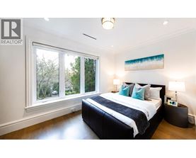 A bedroom with a large bed and a painting on the wall.