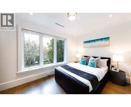 A bedroom with a large bed and a painting on the wall.