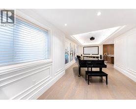 A spacious room with a grand piano and a television mounted on the wall.