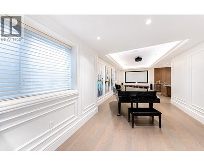 A spacious room with a grand piano and a television mounted on the wall.