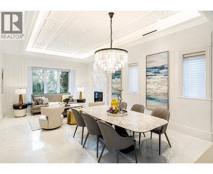 A dining room with a large table and chairs.