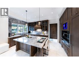 A modern kitchen with dark wood cabinets and a granite countertop.