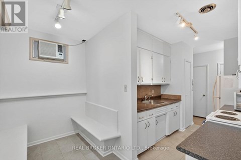 A kitchen with white cabinets and a bench.