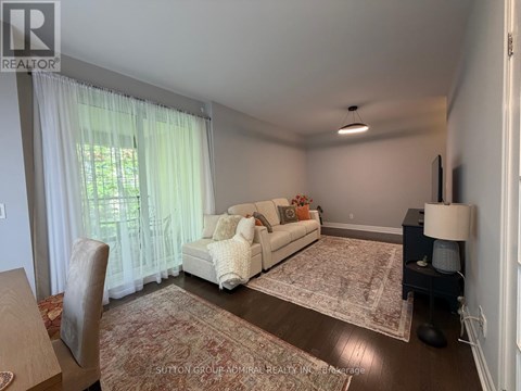 A living room with a white couch and a rug.