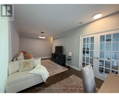 A living room with a couch, a chair, and a television.