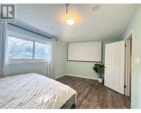 A bedroom with a bed, a window, and a door.