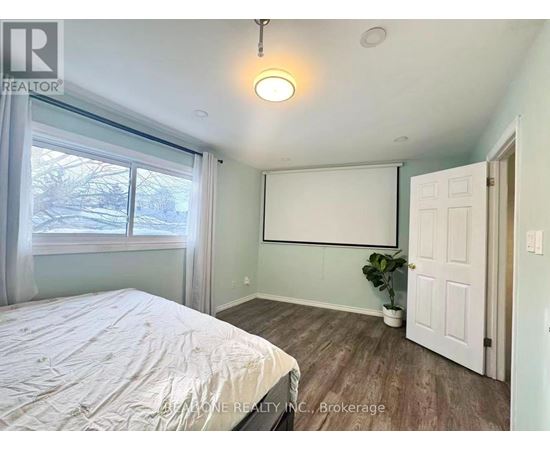 A bedroom with a bed, a window, and a door.