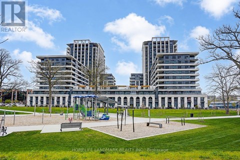 A park with a playground and a building in the background.