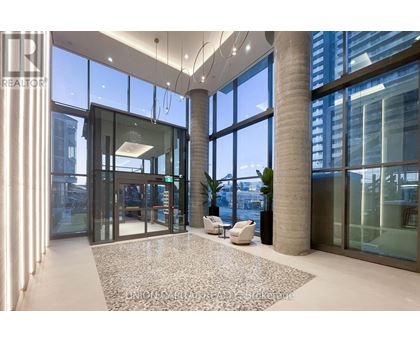 A lobby with a marble floor and a glass wall.