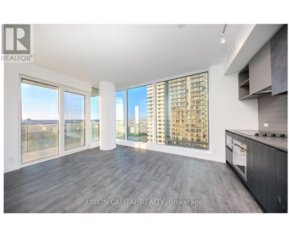 A spacious kitchen with a view of the cityscape outside the large windows.