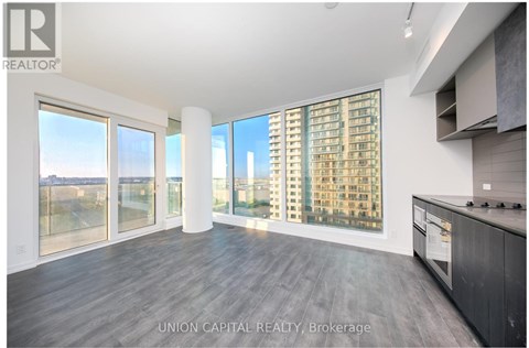A spacious kitchen with a view of the cityscape outside the large windows.