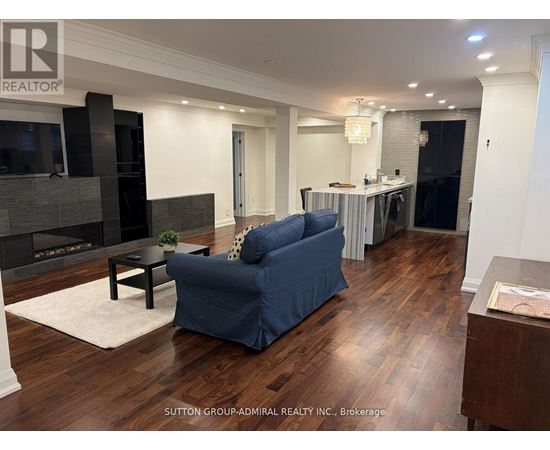 A blue sofa in a living room with wood flooring and a fireplace.