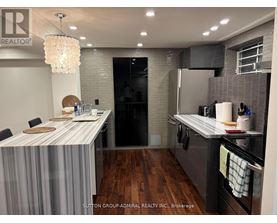 A modern kitchen with a dining table and a chandelier.