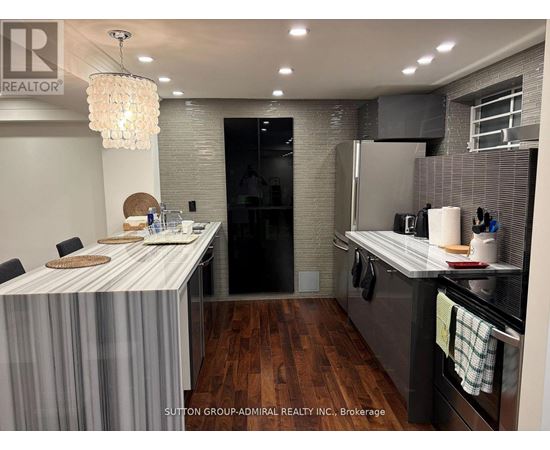 A modern kitchen with a dining table and a chandelier.