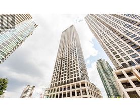 A cityscape with tall buildings and a cloudy sky.